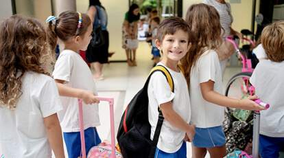 Alunos na fila com menino sorrindo