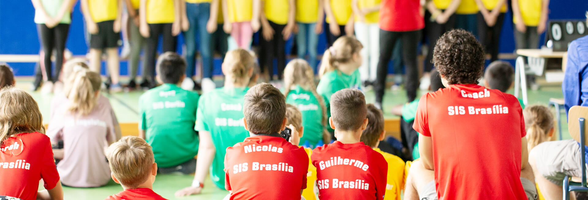 Alunos sentados de costas com camisa SIS Brasilia