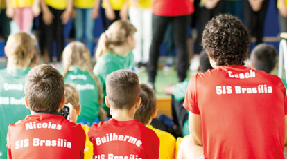 Alunos sentados de costas com camisa SIS Brasilia