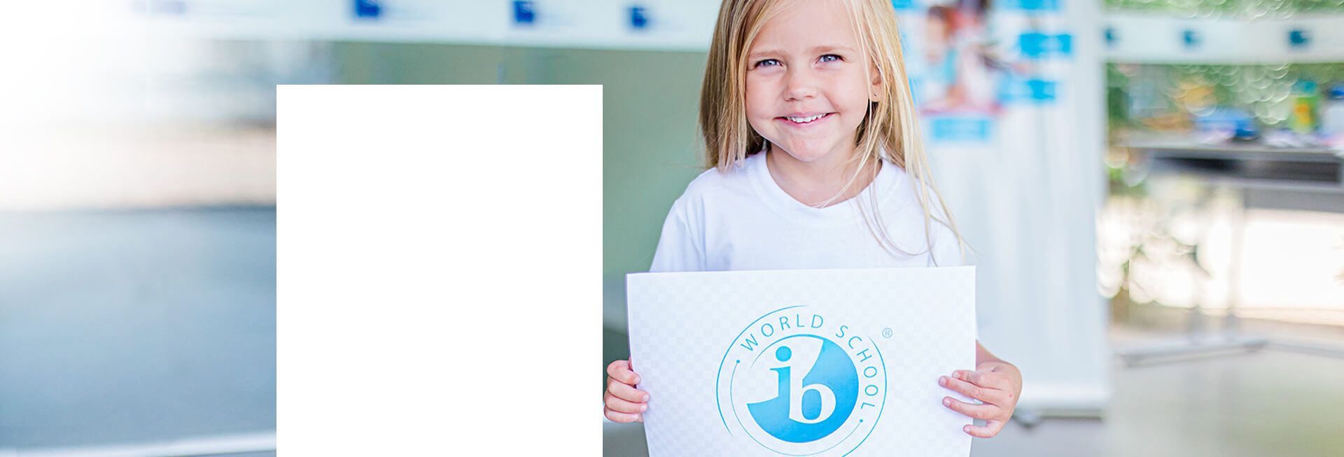 menina segurando um papel com o logo IB