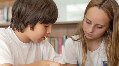 menino e menina lendo em uma biblioteca