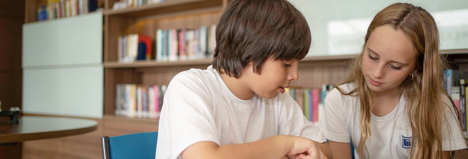 menino e menina lendo em uma biblioteca