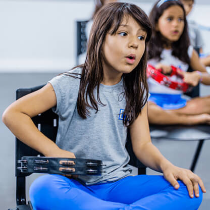 menina tocando pandeirola